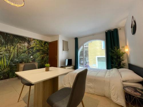 a bedroom with a bed and a table and a window at Draguignan, centre ville wifi jolie deco in Draguignan