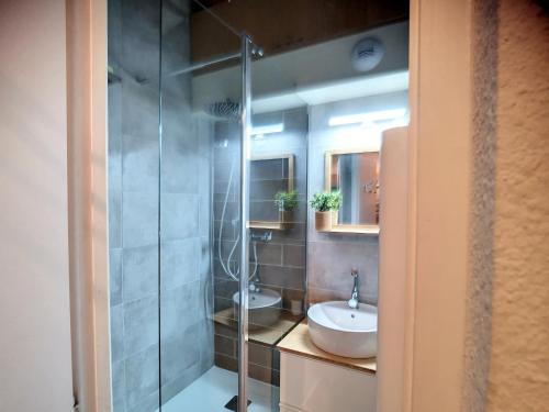 une salle de bain avec deux lavabos et une douche en verre dans l'établissement Studio cabine rénové 4 pers 24m², au pied des pistes, Les Menuires - FR-1-178-183, aux Menuires
