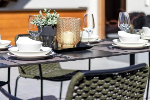 a table with plates and wine glasses on it at Bellavista Apartment in Dobbiaco