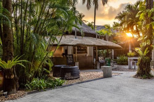 a restaurant with a thatched roof and palm trees at The Dewa Koh Chang in Ko Chang