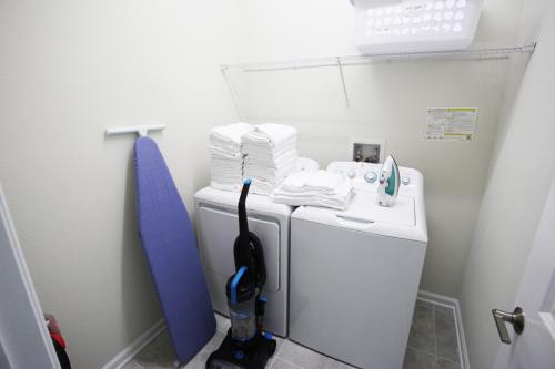 baño pequeño con lavadora y lavamanos en Gorgeous 3Br Condo 10 min Disney, Golf Water Park, en Kissimmee