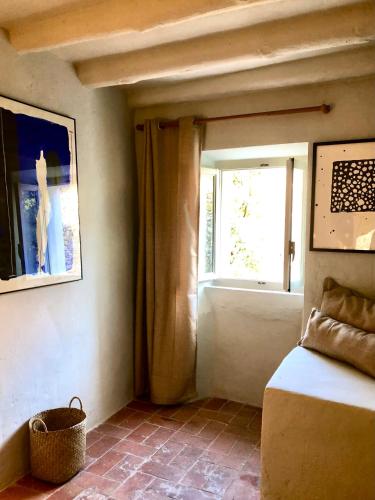 a room with a window and a bed with a basket at El Castell de Segueró in Beuda