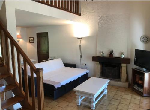 ein Wohnzimmer mit einem Bett und einem Kamin in der Unterkunft Villa au bord du Lac d'Esparron-de-Verdon in Esparron-de-Verdon