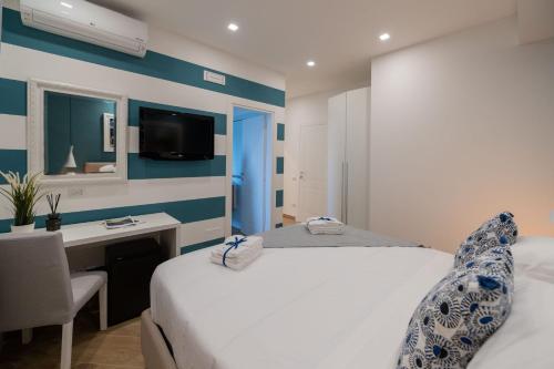 a bedroom with a bed and a desk and a tv at Behome202 in Fisciano