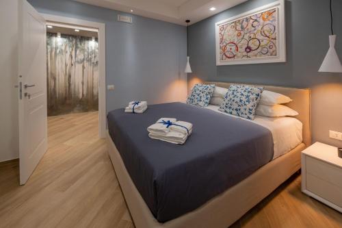 een slaapkamer met een groot bed en handdoeken bij Behome202 in Fisciano