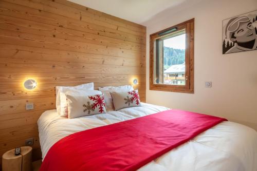 een bed in een kamer met een houten muur bij Echo du Pleney B103 in Morzine