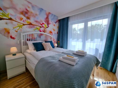 een slaapkamer met een bed met handdoeken erop bij Perła Pomorza Mielno - 365PAM in Unieście