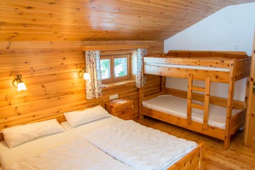 a bedroom with two bunk beds in a cabin at Chalet Neuhofalm Obertauern mit Sauna und Hobbyraum in Obertauern