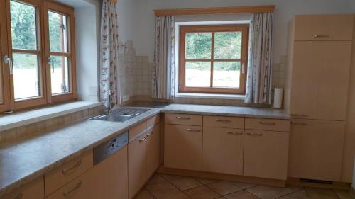 uma cozinha com um lavatório e duas janelas em Chalet Neuhofalm Obertauern mit Sauna und Hobbyraum em Obertauern