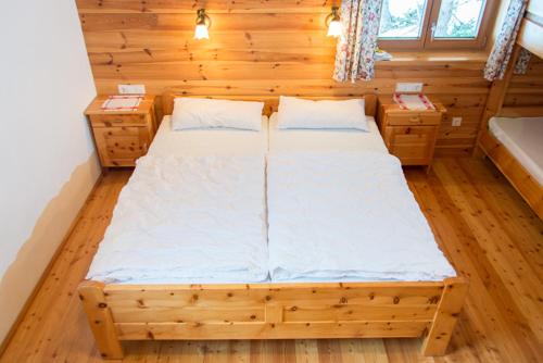 a large bed in a room with wooden floors at Chalet Neuhofalm Obertauern mit Sauna und Hobbyraum in Obertauern