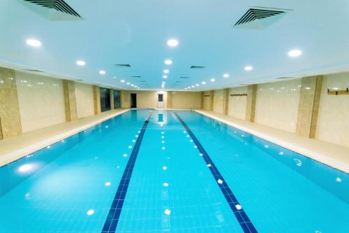 a large indoor swimming pool with blue water at CONNECT THERMAL HOTEL in Ankara