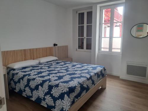 a bedroom with a bed with a blue and white blanket at Superbe appartement T3 au centre plage .Parking in Hendaye