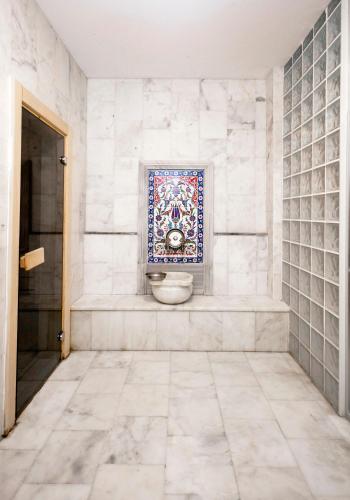 a bathroom with a tiled floor and a tile wall at CONNECT THERMAL HOTEL in Ankara
