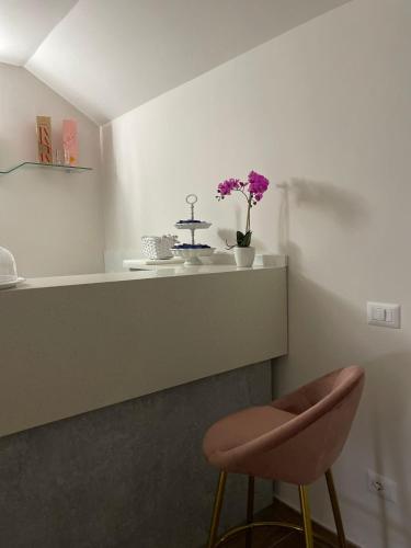 a kitchen with a counter and a stool and flowers at Hotel Villa Ruggiero in Brusciano