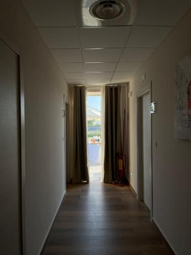 an empty hallway with a hallway leading to a window at Hotel Villa Ruggiero in Brusciano