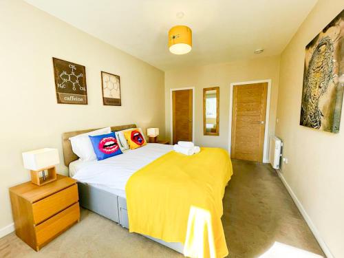 a bedroom with a bed with a yellow blanket on it at Charming Old Town 2 Bed Apt, 2mins from Royal Mile in Edinburgh