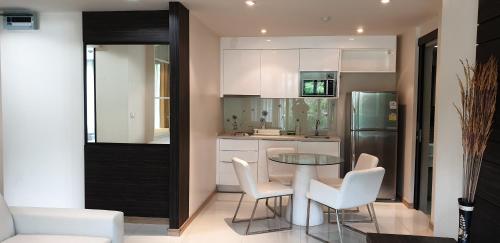 cocina con mesa, sillas y nevera en The Baycliff Residences, en Patong Beach