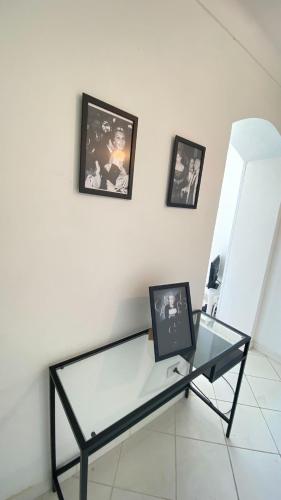 une table en verre dans une pièce avec des photos sur le mur dans l'établissement C060-Bel Appartement avec Vue Mer - Picaud, à Cannes