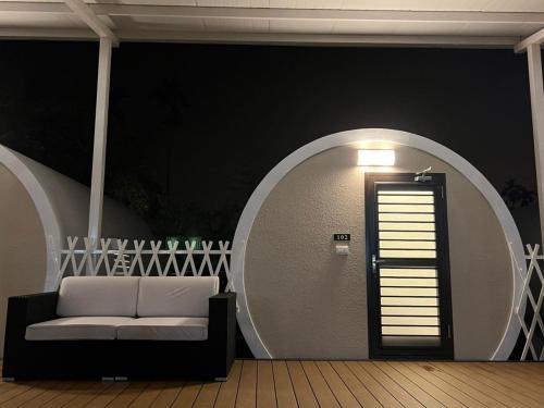 een kamer met een bank en een muur met een deur bij Star & Moon GUEST HOUSE in Puli