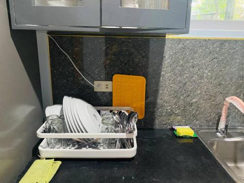 a kitchen counter with a dish drying rack with dishes at B1 - Spacious 3BR House with Netflix, Fiber Wifi, Parking, Balcony in Cagayan de Oro