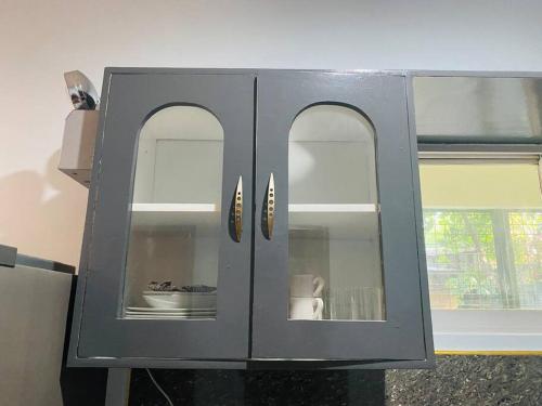 a gray cabinet with three glass doors in a kitchen at B1 - Spacious 3BR House with Netflix, Fiber Wifi, Parking, Balcony in Cagayan de Oro