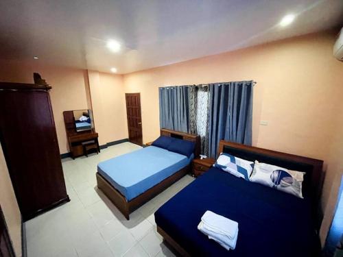 a hotel room with two beds and a television at B1 - Spacious 3BR House with Netflix, Fiber Wifi, Parking, Balcony in Cagayan de Oro