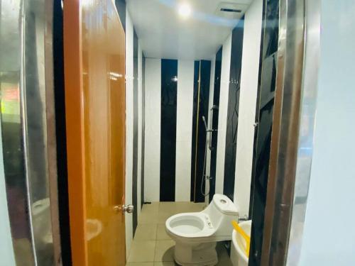 a small bathroom with a toilet in a stall at B1 - Spacious 3BR House with Netflix, Fiber Wifi, Parking, Balcony in Cagayan de Oro