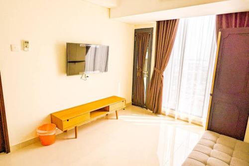 ein Wohnzimmer mit einem Sofa, einem TV und einem Tisch in der Unterkunft Lovina 3508 at Pollux Meisterstadt in Batam Center