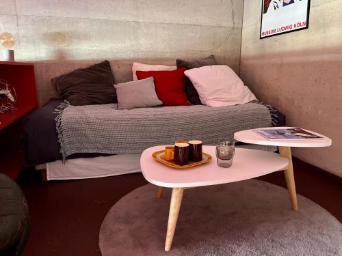 a bed with pillows and a table with a tray on it at LA PORTE ROUGE RBX in Roubaix