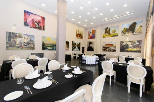 a dining room with tables and chairs and paintings on the walls at CONNECT THERMAL HOTEL in Ankara