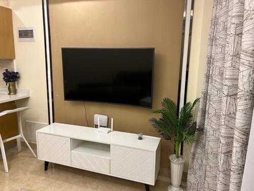 uma sala de estar com um armário branco e uma televisão de ecrã plano em Enzi Heights Apartment Block B em Nairobi