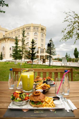 a table with plates of food and a drink at CONNECT THERMAL HOTEL in Ankara