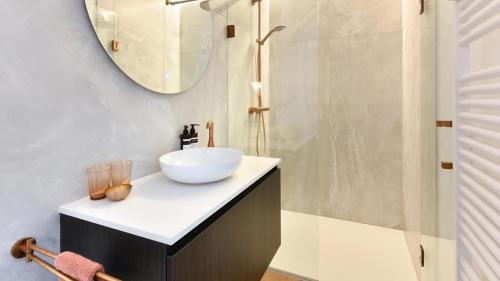 een badkamer met een wastafel en een douche bij Orfeo Knokke in Knokke-Heist