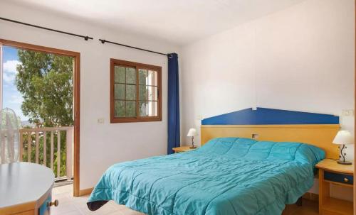 - une chambre avec un lit bleu et un balcon dans l'établissement Holiday Cottage Santa Lucía 1, à Santa Lucía