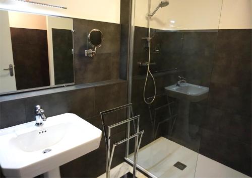 y baño con lavabo y ducha. en Hôtel Le Glacier, en Villeneuve-sur-Lot