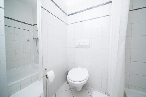 biała łazienka z toaletą i prysznicem w obiekcie WHITE 60 QM Apartment - Zentral - Balkon - Messe w mieście Düsseldorf