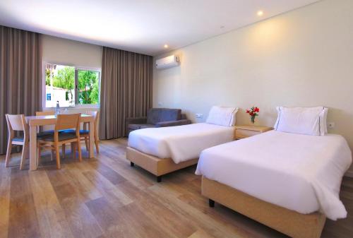 ラゴスにあるAgua Hotels Vila Brancaのベッド2台とテーブルが備わるホテルルームです。
