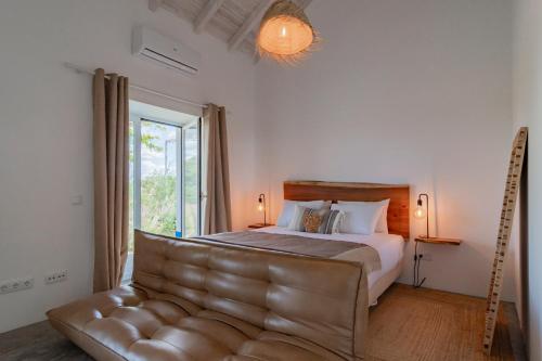 a bedroom with a bed and a leather couch at Monte do Pocinho in São Domingos