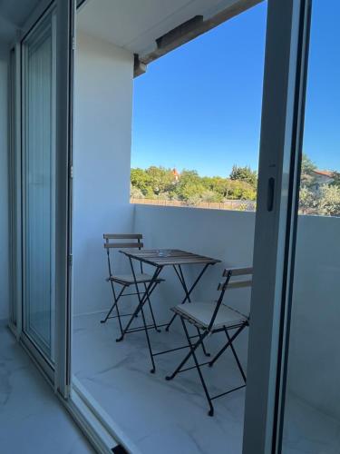 d'un balcon avec une table et des chaises donnant sur l'océan. dans l'établissement Superbe appartement avec balcon et parking, à Aix-en-Provence