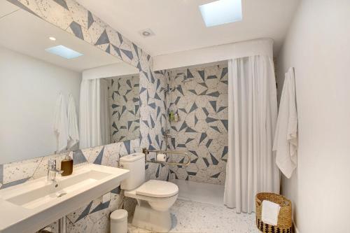 uma casa de banho com um WC branco e um lavatório. em Linaje del Pago Negramol em Sauzal