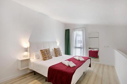 um quarto branco com uma cama grande e um cobertor vermelho em Linaje del Pago Negramol em Sauzal