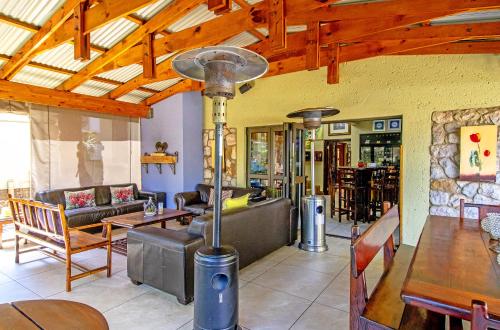 a living room filled with furniture and a wooden ceiling at Afrique Boutique Hotel O.R. Tambo in Boksburg