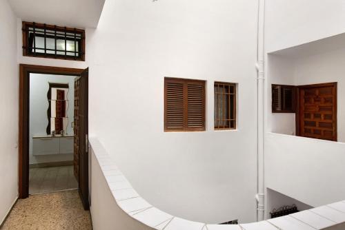 a bathroom with a white wall and a stairway at Cozy Las Canteras beach Apartment in Las Palmas de Gran Canaria