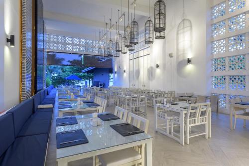 un restaurante con mesas blancas y sillas blancas en Awa Resort Koh Chang en Ko Chang