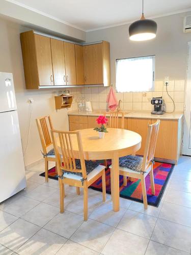 カヴァラにあるKOLOKOTRONIS’ HOUSEのキッチン(木製のテーブル、椅子、冷蔵庫付)