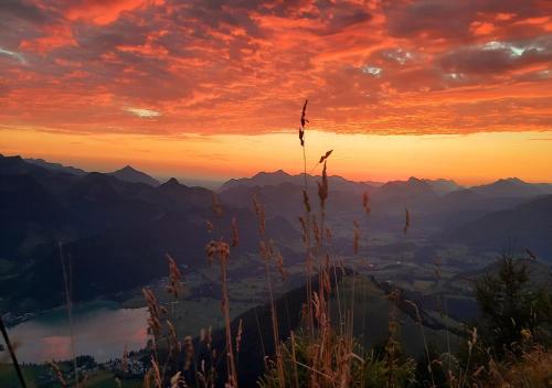 a sunset on a mountain with mountains in the background at Golf- und Sporthotel Moarhof in Walchsee