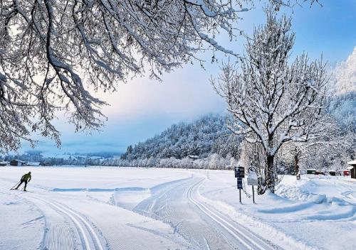 a person is skiing down a snow covered road at Golf- und Sporthotel Moarhof in Walchsee