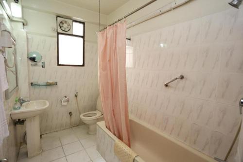 La salle de bains est pourvue d'un lavabo, de toilettes et d'une baignoire. dans l'établissement Meridian Hotel, à Chittagong