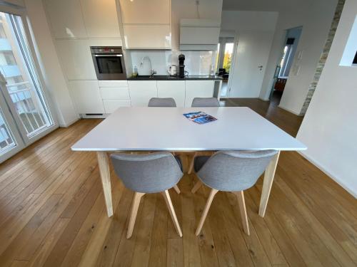 a white table and chairs in a kitchen at Loft Appartement Seven in Friedrichshafen