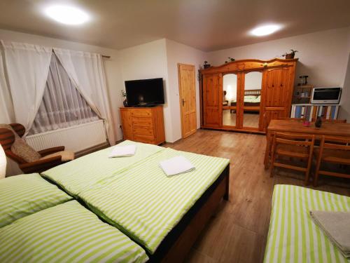 sypialnia z 2 łóżkami, stołem i biurkiem w obiekcie Apartmán na Náměstí 55 w mieście Dürnholz